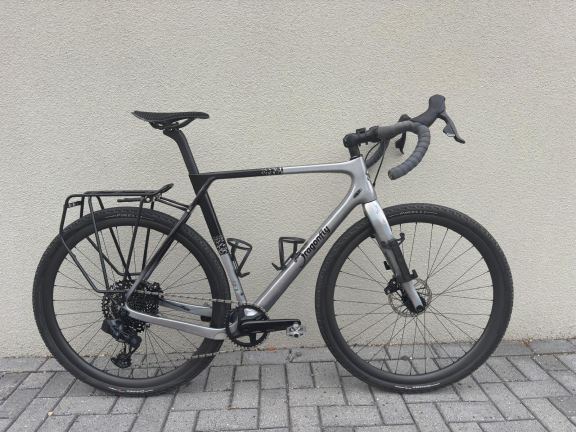Gravelbike op een werkbank omringd door onderhoudsgereedschap en smeermiddelen.