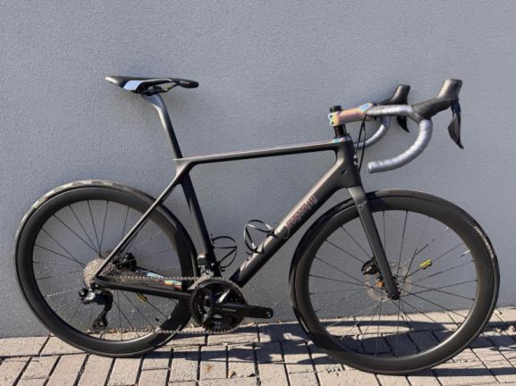 Set fietsonderdelen waaronder remblokjes, ketting en cassette opgeruimd in werkplaats.